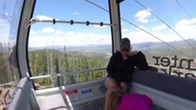 WINTER PARK COLORADO-2019: Girls Riding In A Cable Car Down A Large Forested Slope