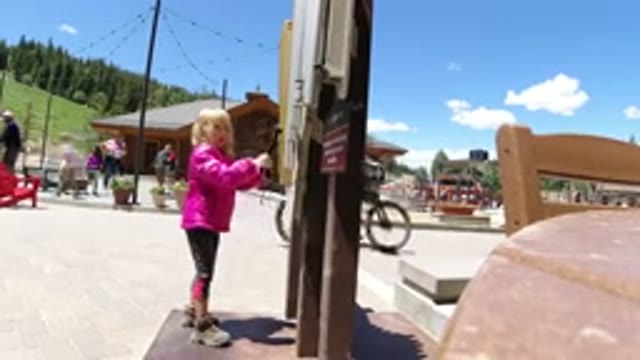 WINTER PARK COLORADO-2019: Child In Pink Jacket Making Music On The Roadside