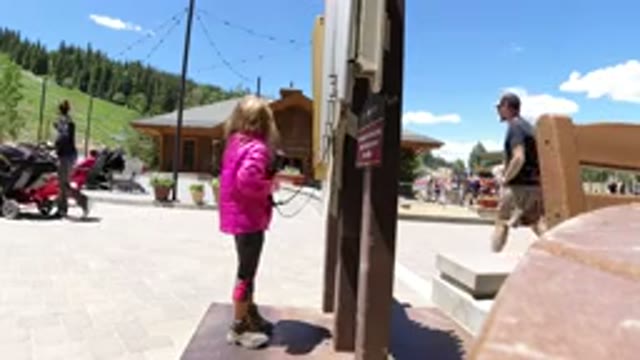 WINTER PARK COLORADO-2019: Girl In Pink Jacket Grabs Phones And Plays With Them