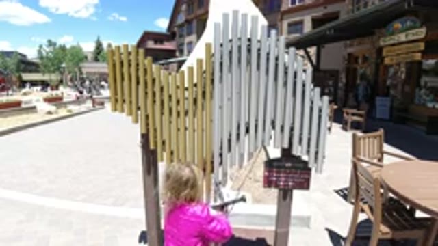 WINTER PARK COLORADO-2019: Little Girl Ringing The Bell In Wooden Shade