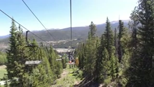 WINTER PARK COLORADO-2019: Traveling Up A Ski Lift Surrounded By Pine Trees In