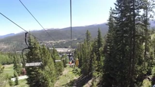 WINTER PARK COLORADO-2019: Ski Lift Footage Passing Through Pine Trees In A Mountainous Area