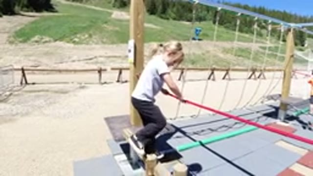 WINTER PARK COLORADO-2019: Girl Holding A Line While Climbing Obstacles In An