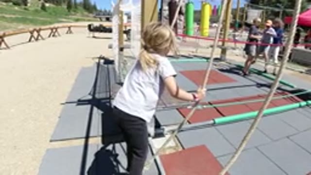 WINTER PARK COLORADO-2019: A Little Girl Walking On A Rope In A Park With Parents