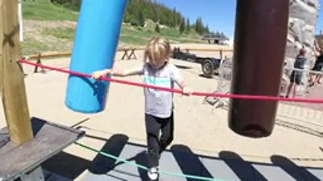 WINTER PARK COLORADO-2019: Blonde Kid Playing On Playground Swings