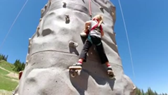 WINTER PARK COLORADO-2019: Little Girl Climbs Slowly Up An Outdoor Rock Wall
