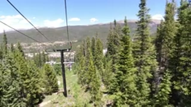 WINTER PARK COLORADO-2019: Chairlift Ascending a Mountain with Pine Trees
