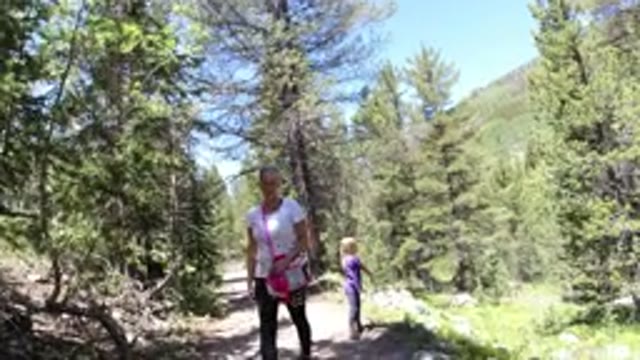 WINTER PARK COLORADO-2019: Two People Walking Along A Trail That Runs Through A