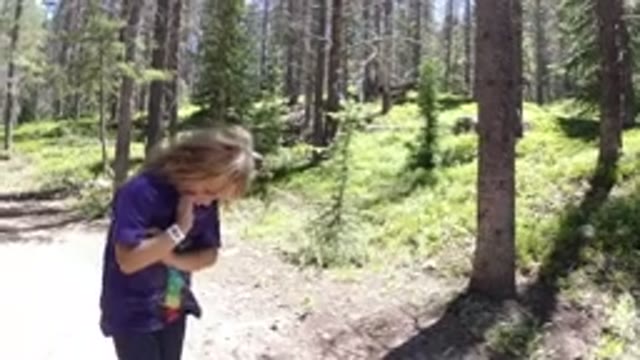 WINTER PARK COLORADO-2019: A Woman In A Purple Shirt Hikes Through The Forest