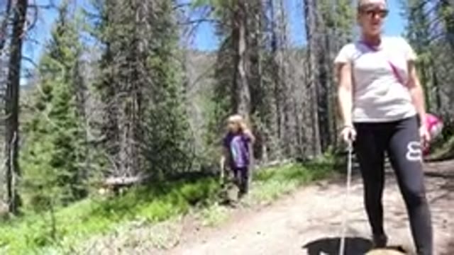 WINTER PARK COLORADO-2019: Woman and Little Girl Walk Through Green Forest