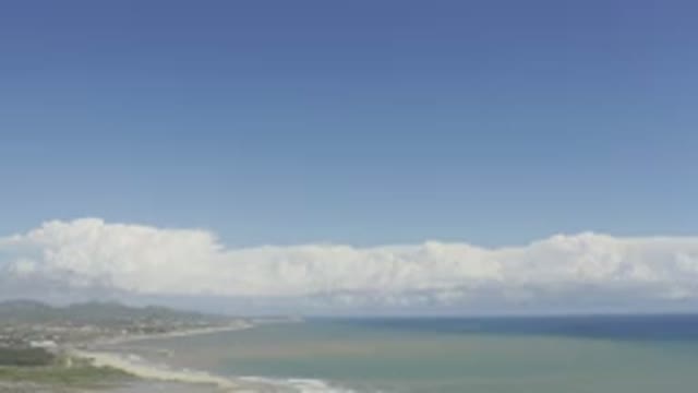 LOS CABOS MEXICO-2019: Pan Down From Sky With Clouds To Waves Crashing On A