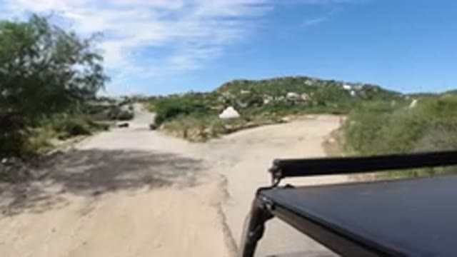 LOS CABOS MEXICO-2019: A Small Black SUV Riding At Moderate Speed On A Sand Road