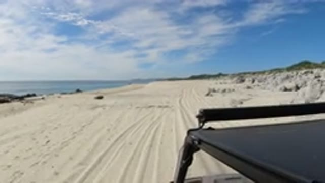 LOS CABOS MEXICO-2019: A Small Black SUV Is Driving On The Beautiful Beach