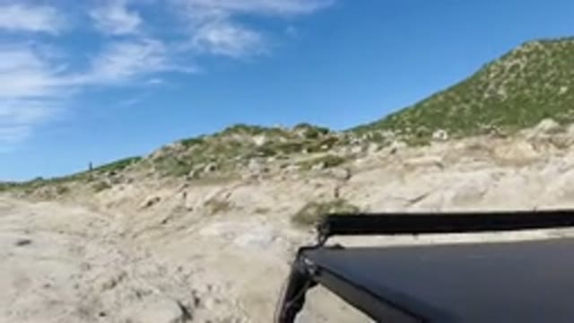 LOS CABOS MEXICO-2019: A Small Black SUV Riding At Moderate Speed On A Rocky Dirt Road
