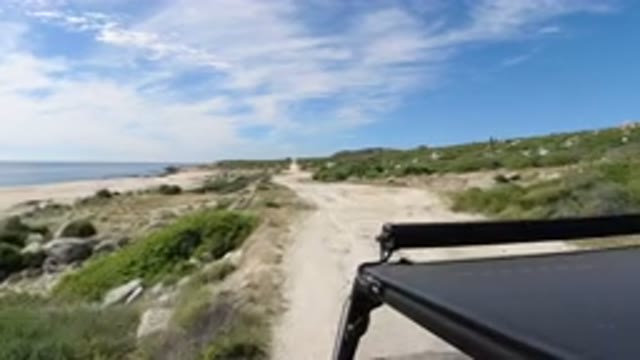 LOS CABOS MEXICO-2019: Car Slowly Driving Through The Beach With Surprisingly