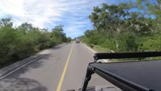 LOS CABOS MEXICO-2019: A Vehicle Driving On A Narrow Road With A Car In Front