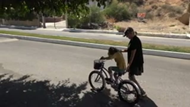 LOS CABOS MEXICO-2020: Adult Woman Helping Young Child Ride Bicycle In Park