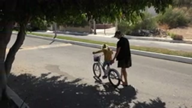 LOS CABOS MEXICO-2020: Mother Acting as Training Wheels for Her Daughter's Bike