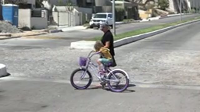 LOS CABOS MEXICO-2020: Father Teaching Daughter How To Ride A Bike On The Street