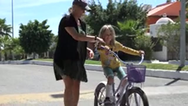 LOS CABOS MEXICO-2020: Mother Teaching Daughter How To Ride A Bike And Helps Her