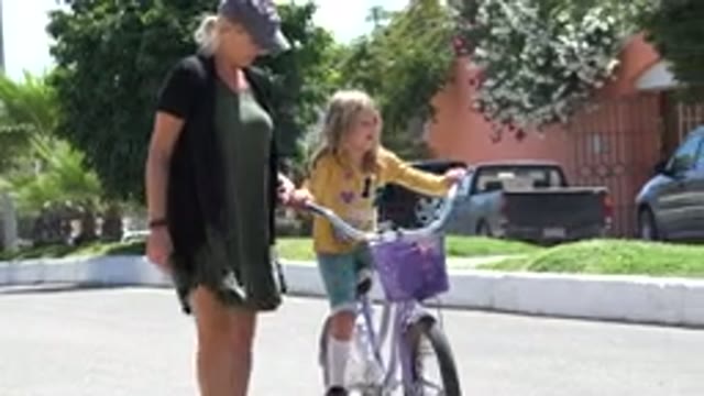 LOS CABOS MEXICO-2020: A Lady Helping A Little Girl Learn To Ride A Bicycle