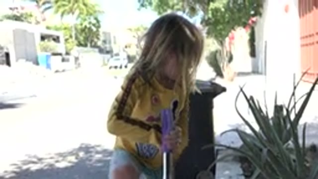 LOS CABOS MEXICO-2020: Young Female Child Wearing Yellow Shirt Pushing Hair