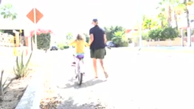 LOS CABOS MEXICO-2020: Woman Helping A Little Girl Ride Her Bike On A Quiet
