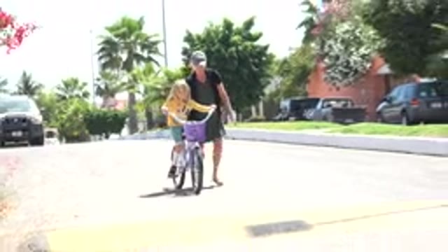 LOS CABOS MEXICO-2020: Mother Teaching Daughter How To Ride A Bicycle Over A