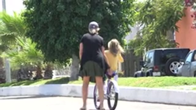 LOS CABOS MEXICO-2020: Woman Helping Little Girl Ride A Bicycle Down The Street
