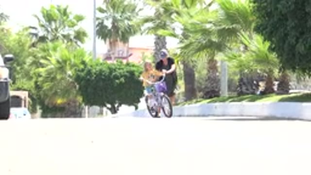 LOS CABOS MEXICO-2020: Father Helping Daughter Ride Her Bike