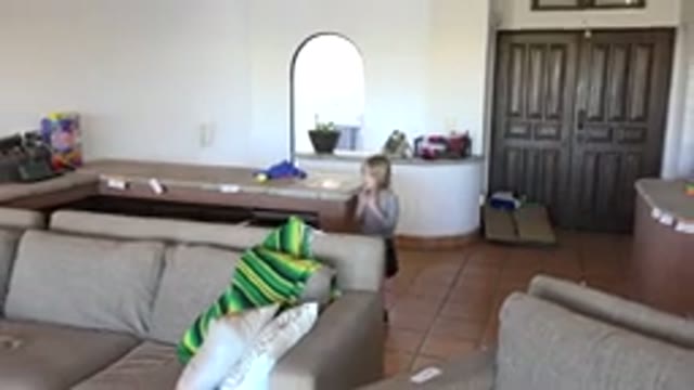 LOS CABOS MEXICO-2020: Small Girl Walks Through Room In House Removing Item From