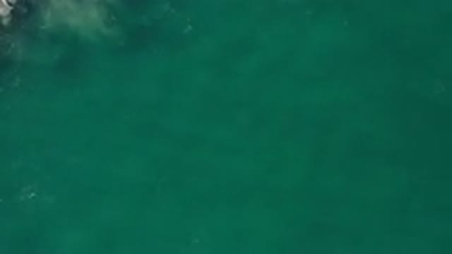 LOS CABOS MEXICO-2020: Sand Is Stirred Up Below Green Ocean Water As It Crashes