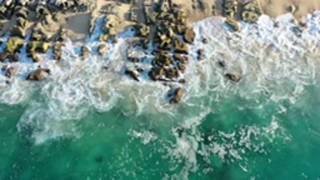 LOS CABOS MEXICO-2020: Green Sea Waves Foam As They Wash Ashore Onto Sandy And