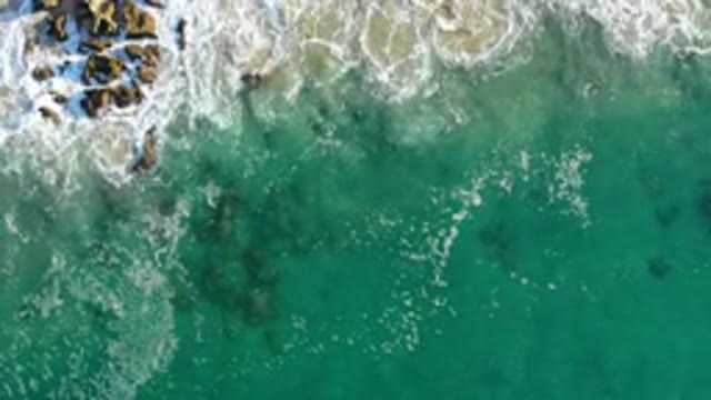 LOS CABOS MEXICO-2020: An Aerial View Of Ocean Waves Crashing Against Brown Rocks