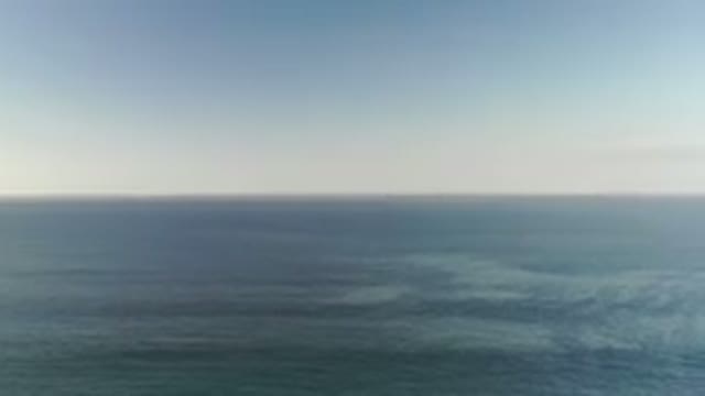 LOS CABOS MEXICO-2020: Panning Downward On A Vibrant Blue Ocean On A Cloudless Day