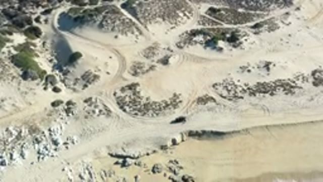 LOS CABOS MEXICO-2020: Sandy Beach With Green Waves Crashing Onto The Tan Sand