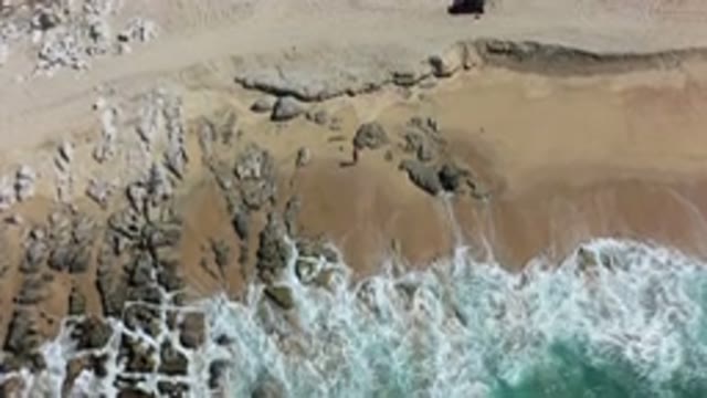 LOS CABOS MEXICO-2020: Waves Rolling Onto Shore And Wash Over Rocks Viewed From