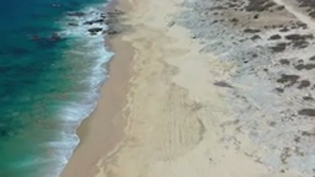LOS CABOS MEXICO-2020: Tide Wet Sand And Rocks On The Shore Of The Beach