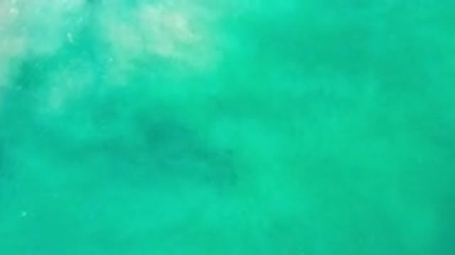 LOS CABOS MEXICO-2020: A Camera Filming Calm Green Ocean Water From Above
