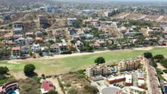 LOS CABOS MEXICO-2020: Houses In A Dry Area With Green Grass And Brown Tile Roofs