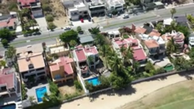 LOS CABOS MEXICO-2020: Drone Footage Zooming Over A Beach Towards Houses
