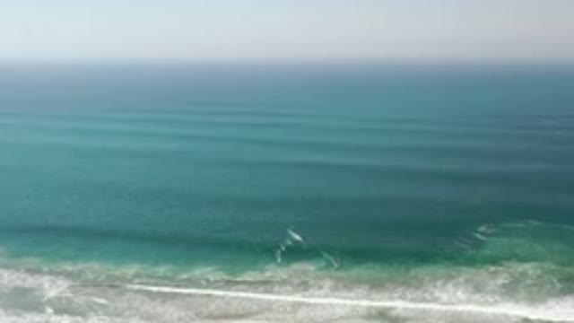 LOS CABOS MEXICO-2020: Hazy Sky Behind A Sea Of Rolling Green Waves Washing Up