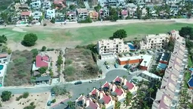 LOS CABOS MEXICO-2020: Green Grass Fields Next To Big Buildings