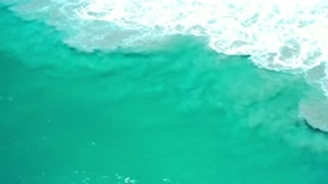 LOS CABOS MEXICO-2020: A White Bubbled Wave Moving Through Green Water
