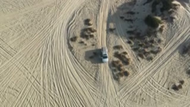 LOS CABOS MEXICO-2020: Overhead Drone Shot Sweeping And Panning Above Car In The Sand