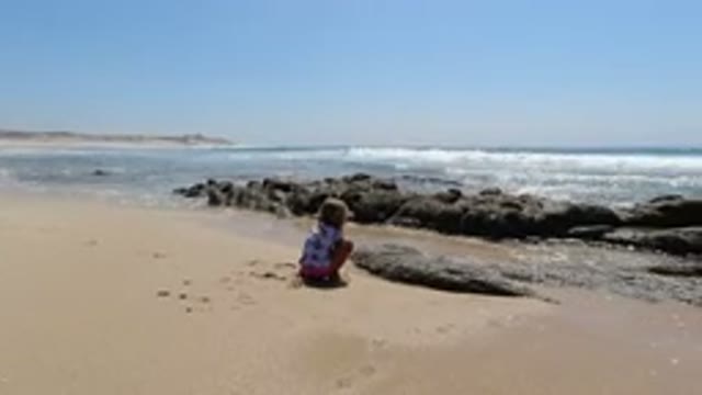 LOS CABOS MEXICO-2020: Little Girl Playing On The Beach With Soft Waves