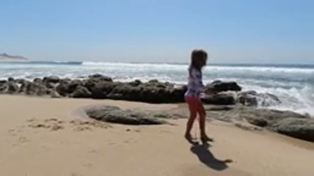 LOS CABOS MEXICO-2020: Young Girl Jumping Into The Water On A Coastal Beach