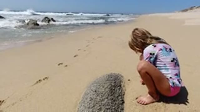 LOS CABOS MEXICO-2020: A Dirty Blonde Haired Girl Wearing Pink Shorts Squats On