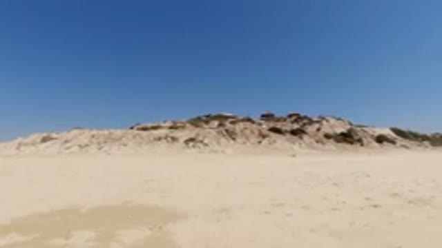 LOS CABOS MEXICO-2020: Little Girl Walking in Bathing Suit Toward Sand Pile