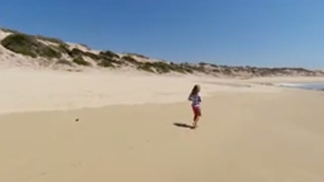 LOS CABOS MEXICO-2020: Girls Walk On Beach Near The Wavy Water And The Tall